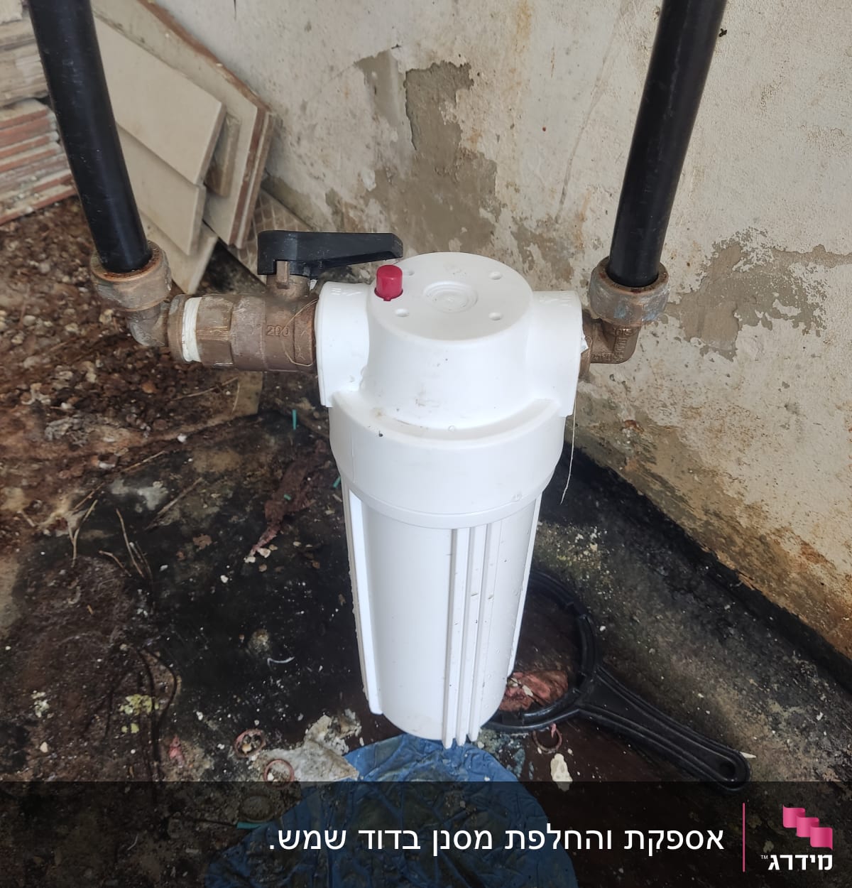 מסנן מים לבן עם צינורות שחורים וחלקי מתכת